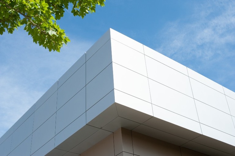 pared exterior de un edificio de estilo comercial contemporáneo con paneles compuestos de metal de aluminio y ventanas de vidrio.
