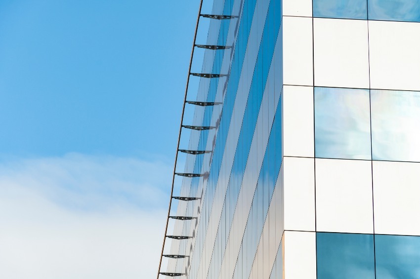 edificio comercial de diseño moderno con paredes de acero y vidrio en el cielo azul